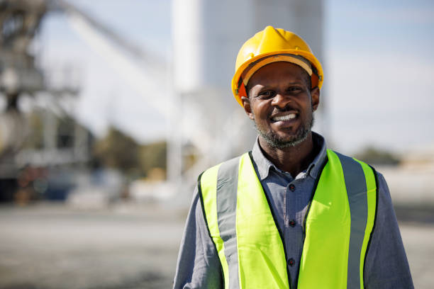 Portrait of smiling engineer with hardhat at construction site Portrait of smiling engineer with hardhat at construction site
