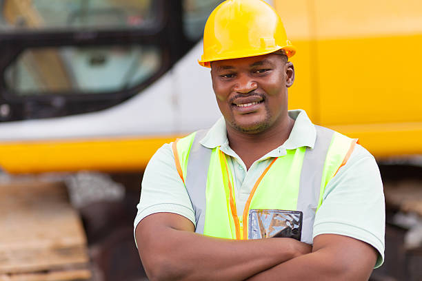 smiling african mine worker with arms folded at mining site smiling african mine worker with arms folded at mining site